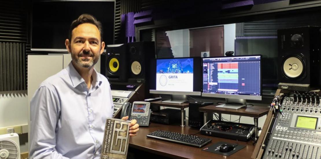 El doctor Juan Miguel Navarro en el estudio de sonido de la UCAM  con el premio de Ingeniero del Año