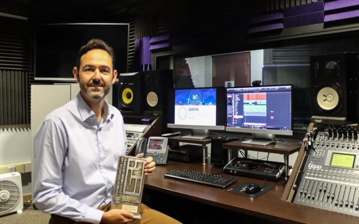 El doctor Juan Miguel Navarro en el estudio de sonido de la UCAM  con el premio de Ingeniero del Año