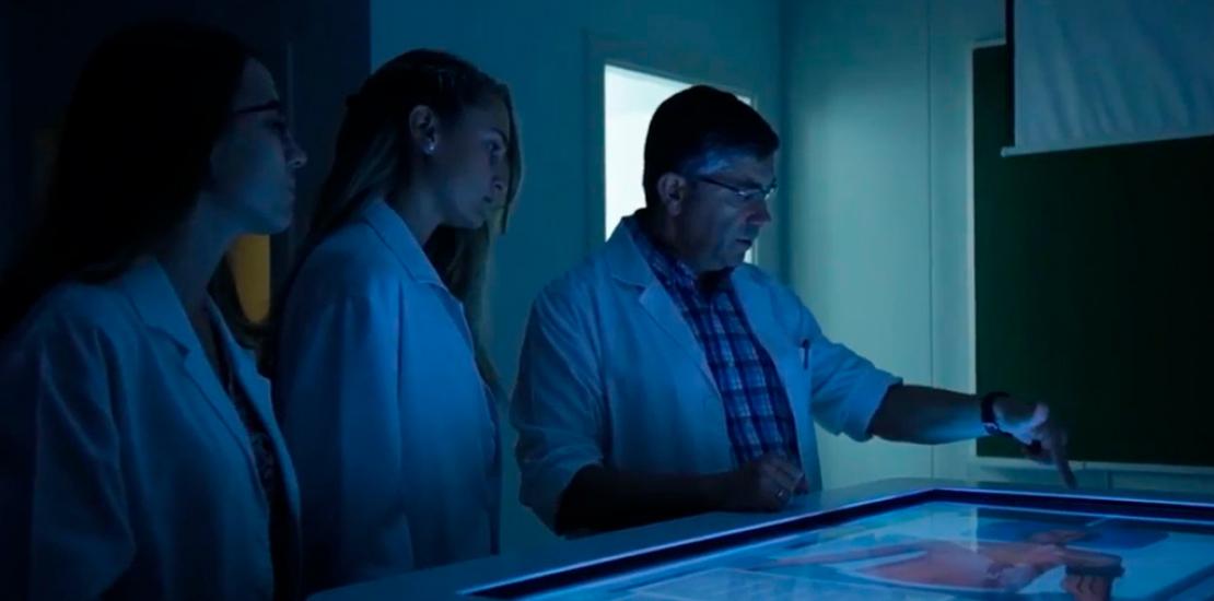 Docente impartiendo clase de medicina utilizando las pantallas de simulación clínica